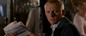 Movie still from “Hot Fuzz” (2007), directed by Edgar Wright – A person reading a newspaper; Close Up shot, Over the shoulder angle