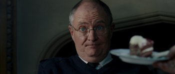 Movie still from “Hot Fuzz” (2007), directed by Edgar Wright – An older man wearing glasses and wearing a tie; Close Up shot, Low angle