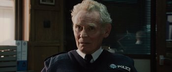 Movie still from “Hot Fuzz” (2007), directed by Edgar Wright – An older man with white hair wearing a police uniform; Close Up shot, Low angle