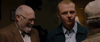Movie still from “Hot Fuzz” (2007), directed by Edgar Wright – A man and a bald man standing next to each other; Close Up shot, Over the shoulder angle