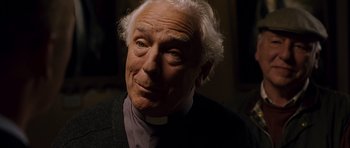 Movie still from “Hot Fuzz” (2007), directed by Edgar Wright – An old man with a white beard and a priest's collar; Close Up shot, Low angle