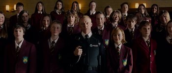 Movie still from “Hot Fuzz” (2007), directed by Edgar Wright – A group of school children posing for a picture with a police officer; Medium shot, Low angle