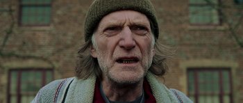 Movie still from “Hot Fuzz” (2007), directed by Edgar Wright – An old man with long hair wearing a hat; Close Up shot, Low angle