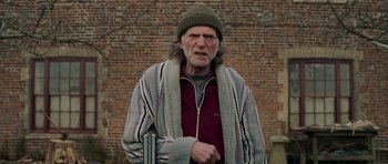 Movie still from “Hot Fuzz” (2007), directed by Edgar Wright – An older man wearing a hat and holding a cane; Medium shot, Over the shoulder angle