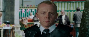 Movie still from “Hot Fuzz” (2007), directed by Edgar Wright – A person wearing a suit and tie; Close Up shot, Over the shoulder angle