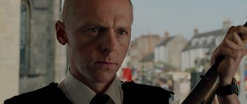 Movie still from “Hot Fuzz” (2007), directed by Edgar Wright – A person wearing a suit and tie; Close Up shot, Over the shoulder angle