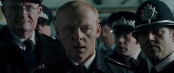Movie still from “Hot Fuzz” (2007), directed by Edgar Wright – A person wearing a police uniform; Close Up shot, Low angle