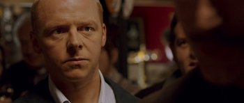 Movie still from “Hot Fuzz” (2007), directed by Edgar Wright – A person wearing a suit and tie; Close Up shot, Over the shoulder angle