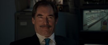 Movie still from “Hot Fuzz” (2007), directed by Edgar Wright – A person wearing a suit and tie; Close Up shot, Over the shoulder angle