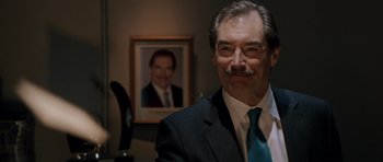 Movie still from “Hot Fuzz” (2007), directed by Edgar Wright – A person wearing a suit and tie; Close Up shot, Over the shoulder angle