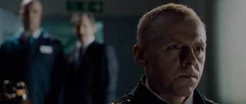 Movie still from “Hot Fuzz” (2007), directed by Edgar Wright – A man in a suit and tie looking into the distance; Close Up shot, Over the shoulder angle