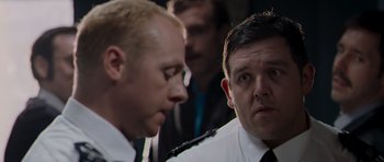 A man in a suit and tie next to another man in a suit and tie