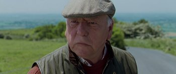 Movie still from “Hot Fuzz” (2007), directed by Edgar Wright – An older man wearing a hat and a jacket; Close Up shot, Low angle