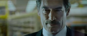 Movie still from “Hot Fuzz” (2007), directed by Edgar Wright – A person wearing a suit and tie; Close Up shot, Over the shoulder angle