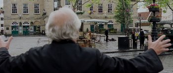 Movie still from “Hot Fuzz” (2007), directed by Edgar Wright – An older man looking out over a city street; Wide shot, Over the shoulder angle