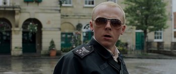 Movie still from “Hot Fuzz” (2007), directed by Edgar Wright – A man in sunglasses and a black jacket; Close Up shot, Over the shoulder angle