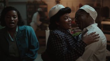Movie still from “A League of Their Own” (2022), created by Abbi Jacobson – A man and a woman are smiling at each other; Medium shot, Over the shoulder angle