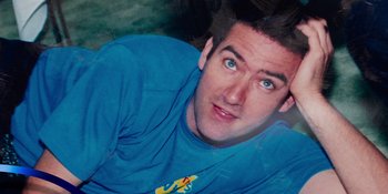 Movie still from “Hot Potato: The Story of the Wiggles” (2023), directed by Fraser Grut – A person wearing a blue t - shirt; Extreme Close Up shot, Overhead angle