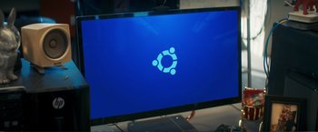 Movie still from “Hot Seat” (2022), directed by James Cullen Bressack – A computer monitor displaying the logo of a computer operating system; Extreme Close Up shot, Overhead angle