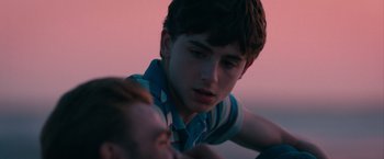 Movie still from “Hot Summer Nights” (2017), directed by Elijah Bynum – A young man looking down at another young man; Close Up shot, Over the shoulder angle