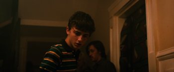 Movie still from “Hot Summer Nights” (2017), directed by Elijah Bynum – A young man standing next to another young woman; Medium shot, Over the shoulder angle