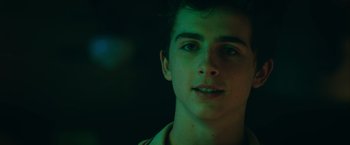 Movie still from “Hot Summer Nights” (2017), directed by Elijah Bynum – A young man's face in the dark; Close Up shot, Over the shoulder angle