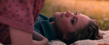 A woman laying on the ground looking up at the sky