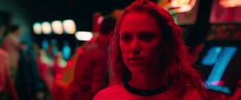 A young woman is standing in a dark room