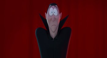 Movie still from “Hotel Transylvania 4: Transformania” (2022), directed by Jennifer Kluska – A cartoon of a man wearing a black shirt and a black cape; Close Up shot, Low angle