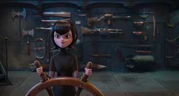 Movie still from “Hotel Transylvania 4: Transformania” (2022), directed by Jennifer Kluska – A woman in a black dress holding a steering wheel in a room filled with guns; Medium shot, High angle