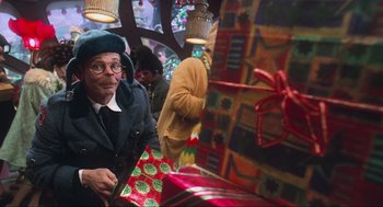 Movie still from “How the Grinch Stole Christmas” (2000), directed by Ron Howard – An old man wearing a hat and holding a gift bag; Close Up shot, Over the shoulder angle