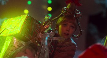 Movie still from “How the Grinch Stole Christmas” (2000), directed by Ron Howard – A young girl wearing a christmas hat and holding a bottle; Close Up shot, Over the shoulder angle