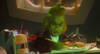 Movie still from “How the Grinch Stole Christmas” (2000), directed by Ron Howard – A man dressed as the grinch sitting at a table; Close Up shot, Over the shoulder angle