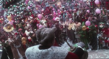 Movie still from “How the Grinch Stole Christmas” (2000), directed by Ron Howard – A crowd of people gathered around a man with a microphone; Wide shot, High angle