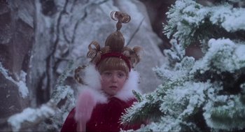 Movie still from “How the Grinch Stole Christmas” (2000), directed by Ron Howard – A young girl in a red coat and a wig on top of a tree; Close Up shot, Over the shoulder angle