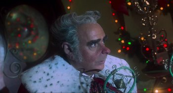 Movie still from “How the Grinch Stole Christmas” (2000), directed by Ron Howard – An older man in a white fur coat looking to his left; Close Up shot, Low angle