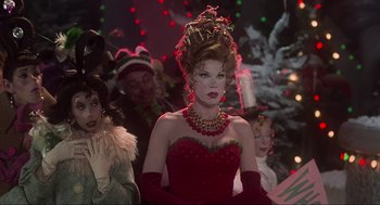 Movie still from “How the Grinch Stole Christmas” (2000), directed by Ron Howard – A woman in a red dress with a bunch of people in the background; Medium shot, Over the shoulder angle