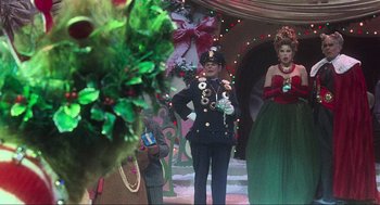 Movie still from “How the Grinch Stole Christmas” (2000), directed by Ron Howard – A man in a military uniform standing next to a woman in a green dress; Medium shot, Over the shoulder angle