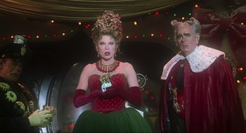 Movie still from “How the Grinch Stole Christmas” (2000), directed by Ron Howard – A woman dressed as the grinch stands next to a man dressed as santa claus; Medium shot, Low angle