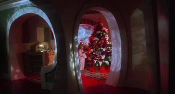 Movie still from “How the Grinch Stole Christmas” (2000), directed by Ron Howard – A christmas tree is lit up in a room with arches; Extreme Wide shot, Low angle