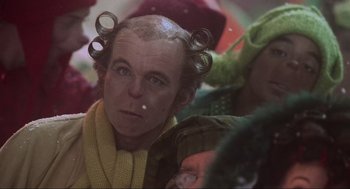 Movie still from “How the Grinch Stole Christmas” (2000), directed by Ron Howard – A man with curlers in his hair is sitting in front of a crowd; Close Up shot, Low angle