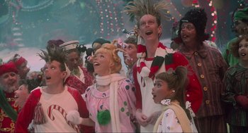 Movie still from “How the Grinch Stole Christmas” (2000), directed by Ron Howard – A group of people dressed up in costumes singing; Medium shot, Low angle