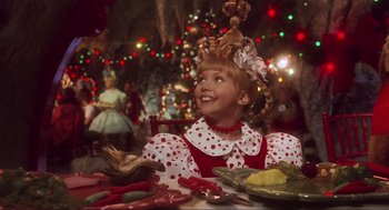 Movie still from “How the Grinch Stole Christmas” (2000), directed by Ron Howard – A little girl sitting at a table with a plate of food in front of her; Close Up shot, Over the shoulder angle
