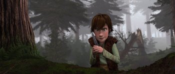 Movie still from “How to Train Your Dragon” (2010), directed by Chris Sanders – A boy is holding a knife in the woods; Medium shot, High angle