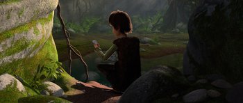 Movie still from “How to Train Your Dragon” (2010), directed by Chris Sanders – A person sitting on the ground holding a remote control; Wide shot, High angle