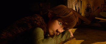 Movie still from “How to Train Your Dragon” (2010), directed by Chris Sanders – A boy with green eyes is leaning on a wall; Medium shot, High angle
