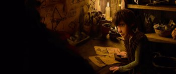 Movie still from “How to Train Your Dragon” (2010), directed by Chris Sanders – A young boy sitting at a wooden table; Medium shot, High angle