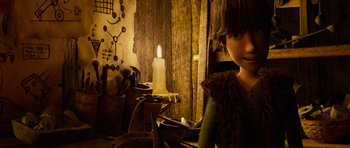 Movie still from “How to Train Your Dragon” (2010), directed by Chris Sanders – A young boy is sitting in front of a lit candle; Medium shot, High angle