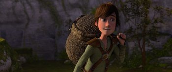 Movie still from “How to Train Your Dragon” (2010), directed by Chris Sanders – A young boy with a large bag of hay on his back; Medium shot, High angle