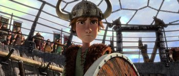 Movie still from “How to Train Your Dragon” (2010), directed by Chris Sanders – A young boy wearing a helmet and holding a shield; Close Up shot, Low angle